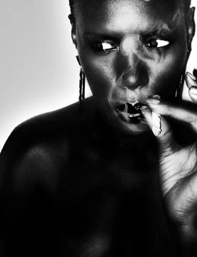 A black-and-white portrait, cigarette in hand.